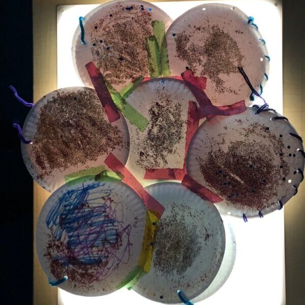 Several paper plates taped together and decorated into a glittery dress.